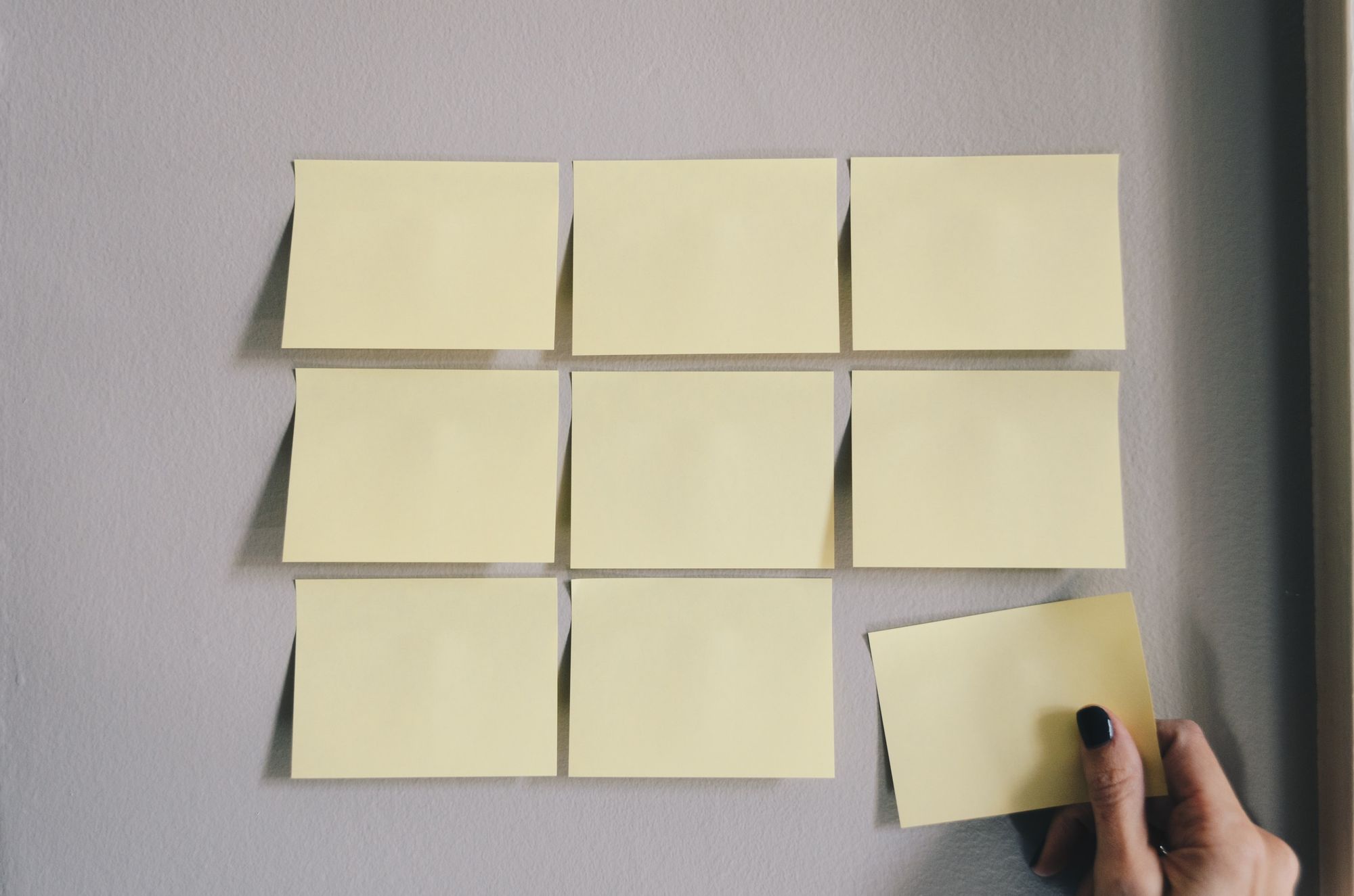 Nine empty sticky notes stuck to the wall.
