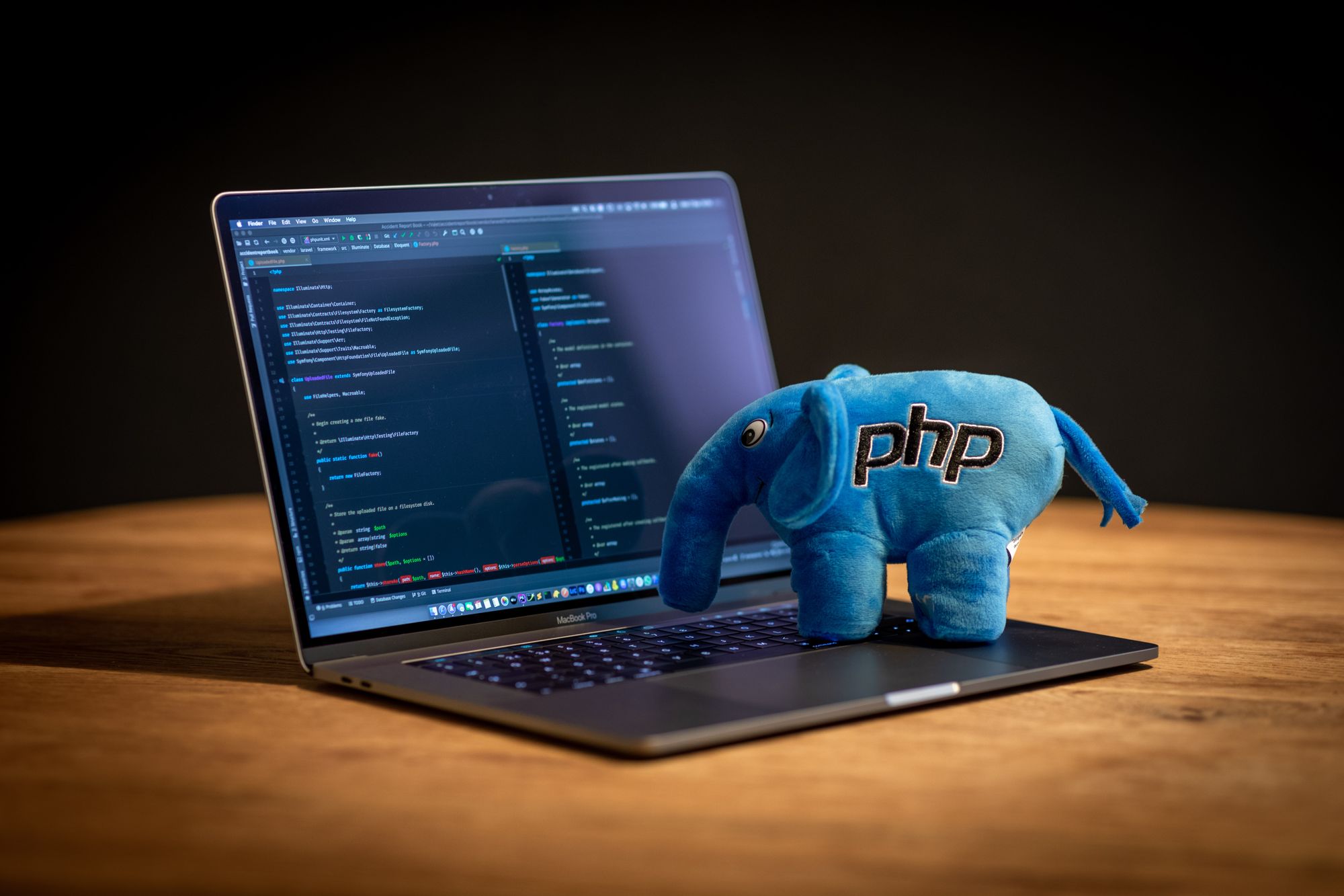 Plushy elephant with PHP written on it, standing on top of a MacBook keyboard.