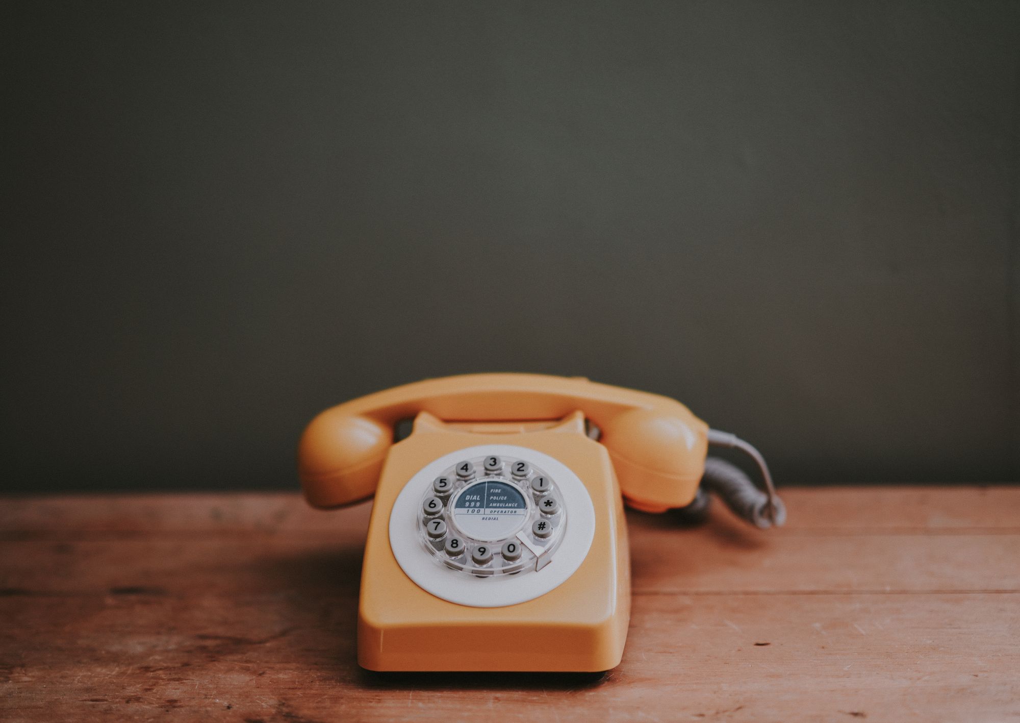 Orange telephone with a circular number pad.