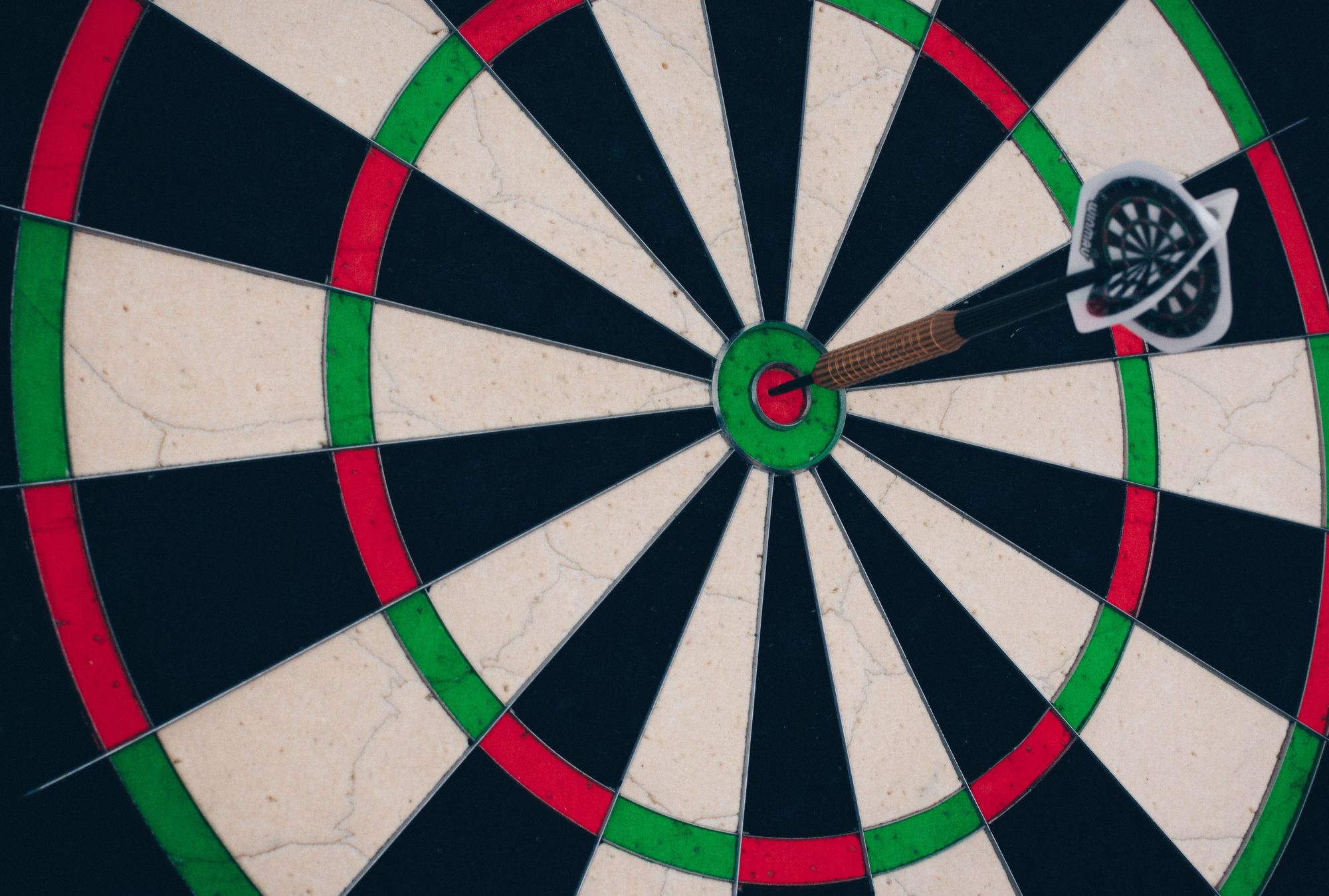 Dartboard with a dart in the bullseye.