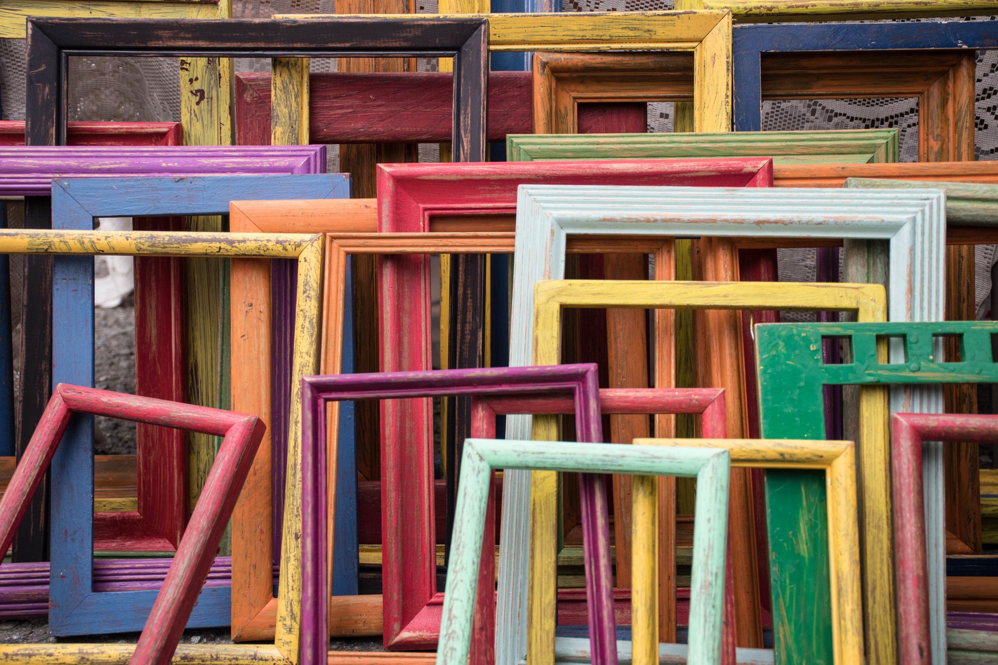 Many colorful and empty frames stacked next to and behind each other.