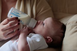 Woman holding baby in her arm while bottle feeding.