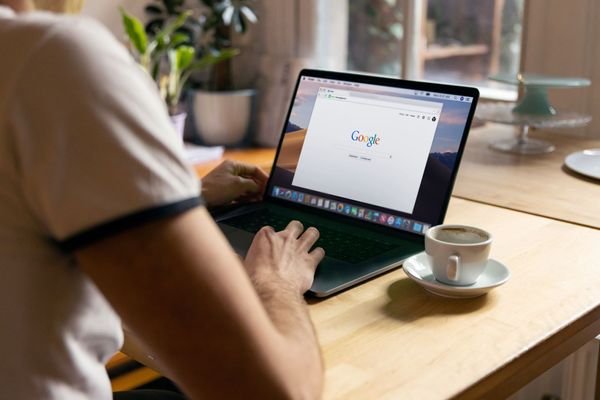 Man sitting at table with laptop, getting ready to do a search online.