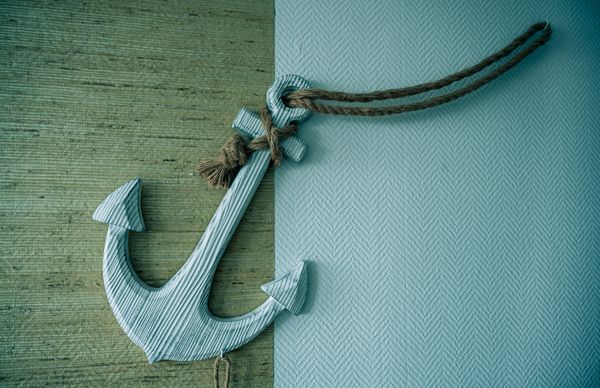 Wooden anchor with a string on a piece of cloth.