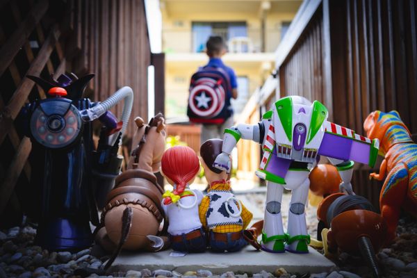 Characters from Toy Story facing away to send a child off to school.